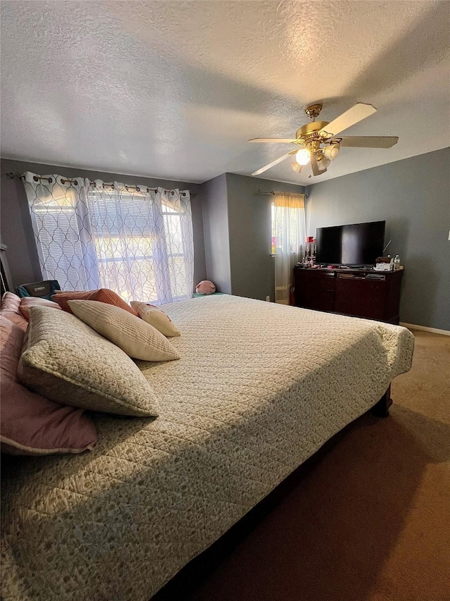 bedroom with a textured ceiling, carpet floors, and a ceiling fan