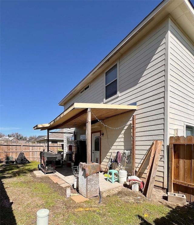 rear view of house featuring a patio area and fence