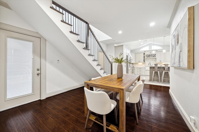 dining space featuring lofted ceiling, recessed lighting, dark wood-style flooring, baseboards, and stairway