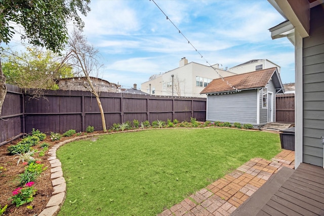 view of yard featuring a fenced backyard, a storage unit, and an outdoor structure