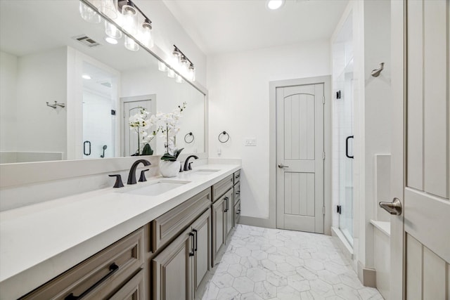 full bath featuring double vanity, a stall shower, visible vents, and a sink