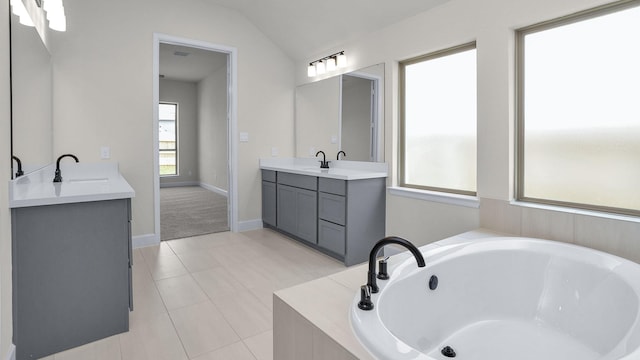 21207 Palm Arbor Dr, Cypress, TX 77433 - bathroom featuring two vanities, a bath, tile patterned floors, and vaulted ceiling