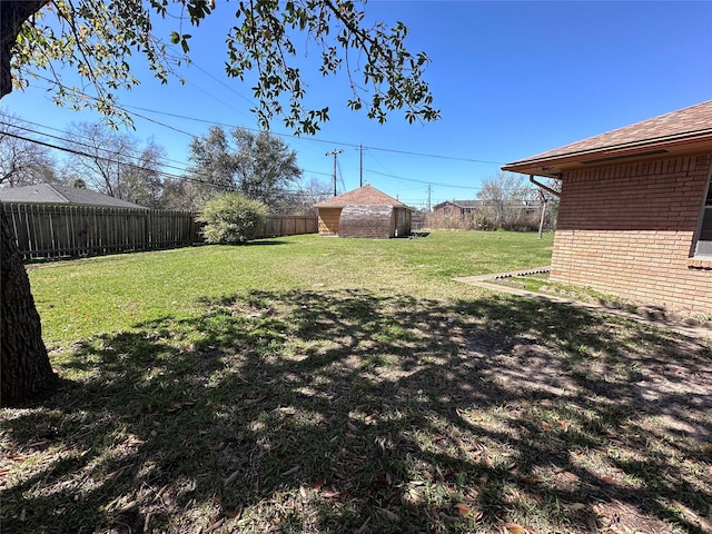 view of yard featuring an outbuilding, a shed, and a fenced backyard