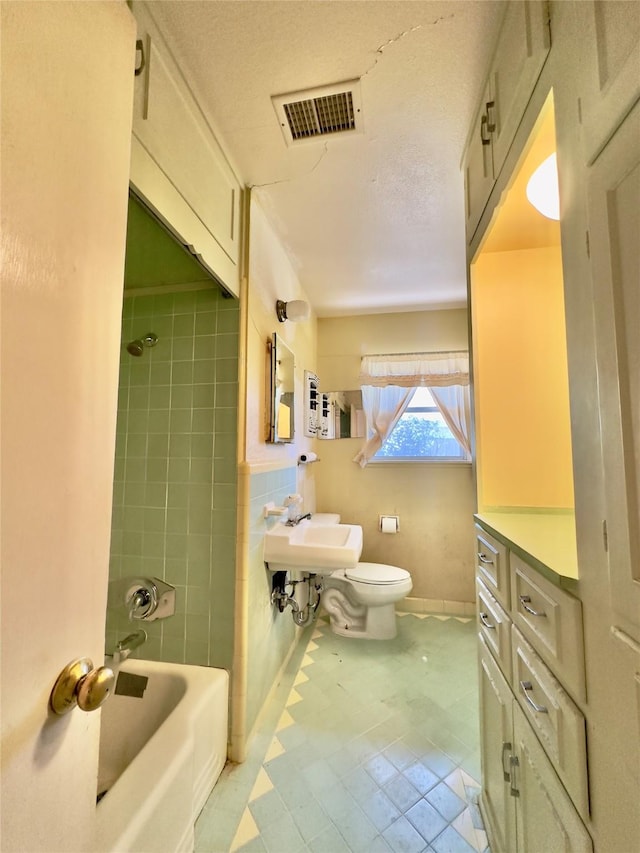 full bath with bathtub / shower combination, visible vents, tile walls, and toilet