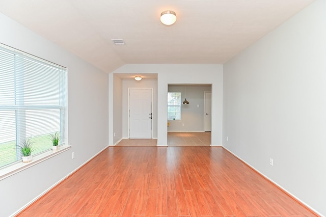 unfurnished room with light wood-type flooring, visible vents, and plenty of natural light