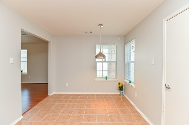 unfurnished room featuring light tile patterned floors, baseboards, and visible vents