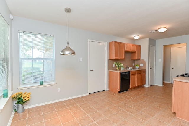 kitchen featuring visible vents, a sink, light countertops, black dishwasher, and a wealth of natural light