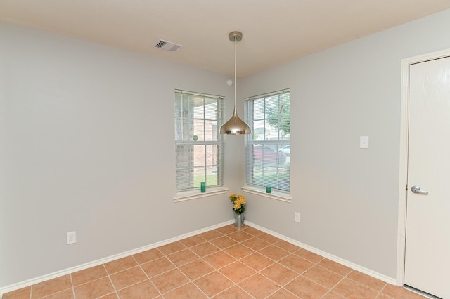 spare room with light tile patterned flooring, visible vents, and baseboards