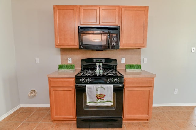 kitchen with light tile patterned floors, black appliances, light countertops, and baseboards