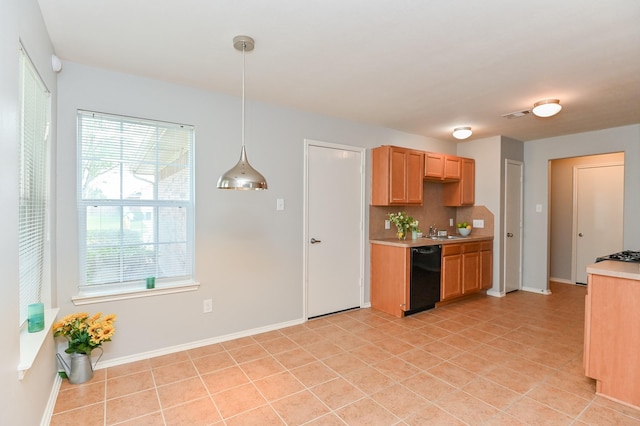 kitchen featuring tasteful backsplash, visible vents, light countertops, black dishwasher, and a sink