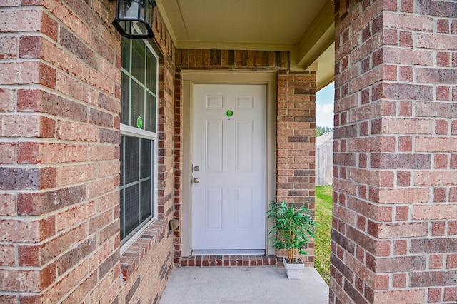 doorway to property featuring brick siding