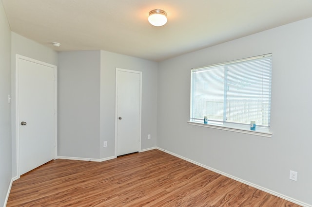 spare room featuring wood finished floors and baseboards