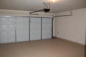 garage featuring a garage door opener and baseboards