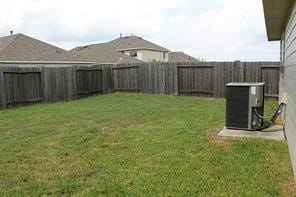 view of yard with central air condition unit and a fenced backyard