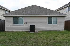 rear view of property with a lawn and fence