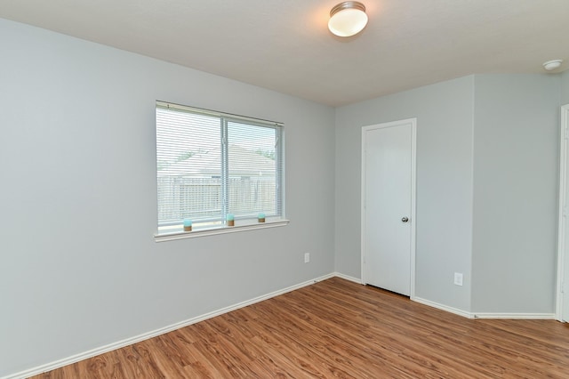 empty room with wood finished floors and baseboards