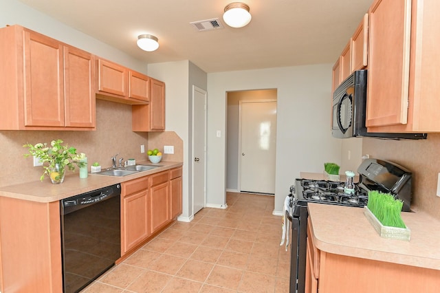 kitchen with visible vents, light brown cabinets, light countertops, black appliances, and a sink