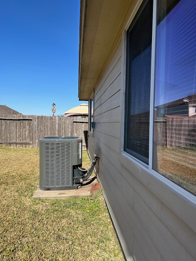 view of yard with fence and central AC