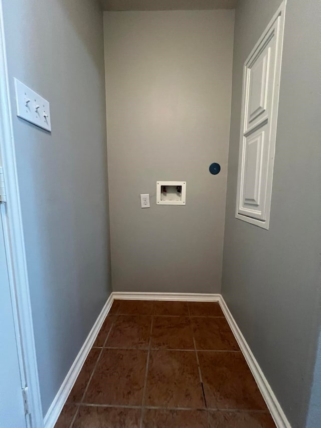 clothes washing area featuring dark tile patterned floors, laundry area, hookup for a washing machine, and baseboards