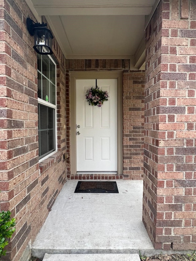 view of exterior entry with brick siding