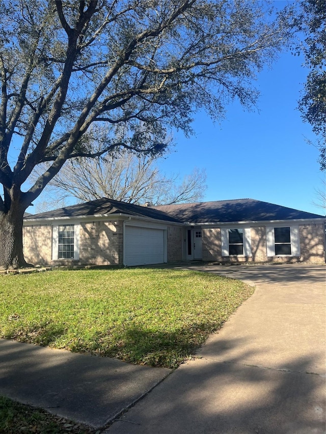 ranch-style home featuring a garage, concrete driveway, brick siding, and a front yard