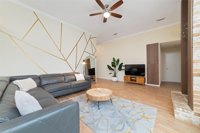 living room with visible vents, baseboards, a ceiling fan, light wood-style flooring, and crown molding