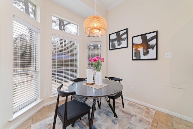 dining area with stone tile floors, baseboards, and ornamental molding