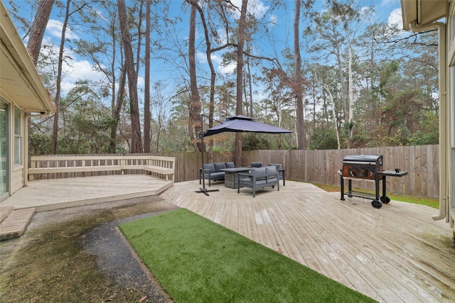 deck with outdoor lounge area, a fenced backyard, and grilling area