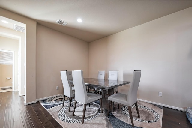 dining room with wood finished floors, visible vents, and baseboards