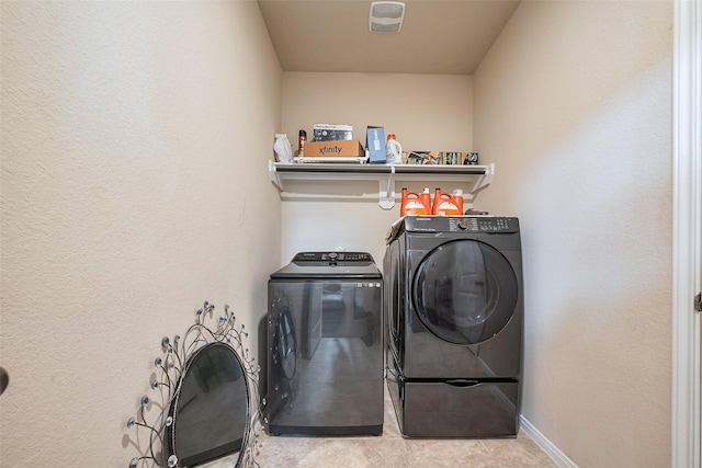 clothes washing area featuring laundry area, baseboards, washer and clothes dryer, and tile patterned floors