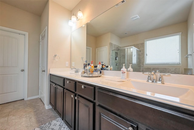 bathroom featuring double vanity, a shower stall, visible vents, and a sink