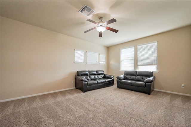 living room with ceiling fan, carpet flooring, visible vents, and baseboards