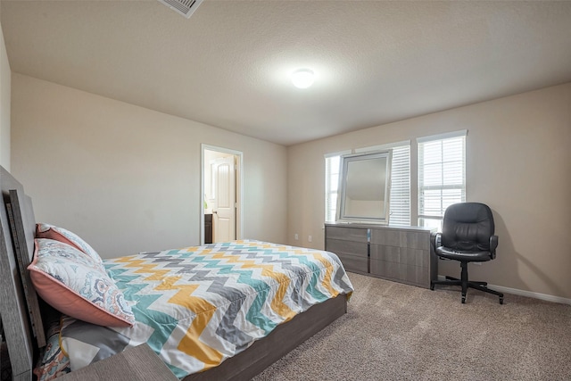 carpeted bedroom featuring a textured ceiling and baseboards