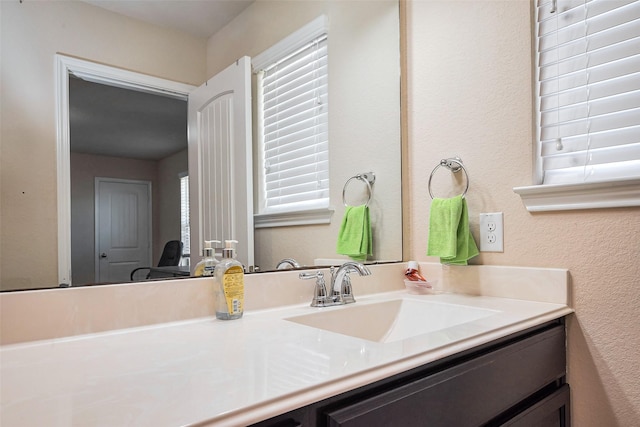 bathroom featuring a textured wall and vanity