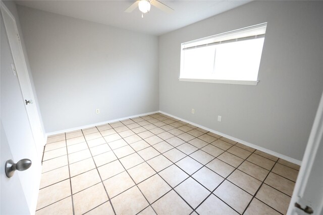 unfurnished room featuring a ceiling fan and baseboards