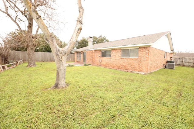 view of yard with a fenced backyard and central air condition unit