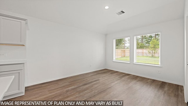 unfurnished room with light wood-style flooring, visible vents, baseboards, and recessed lighting