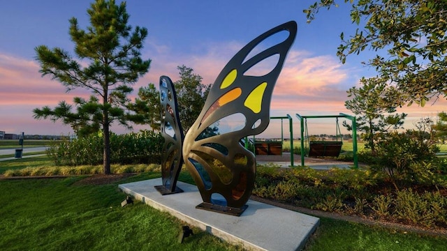 playground at dusk featuring playground community and a yard