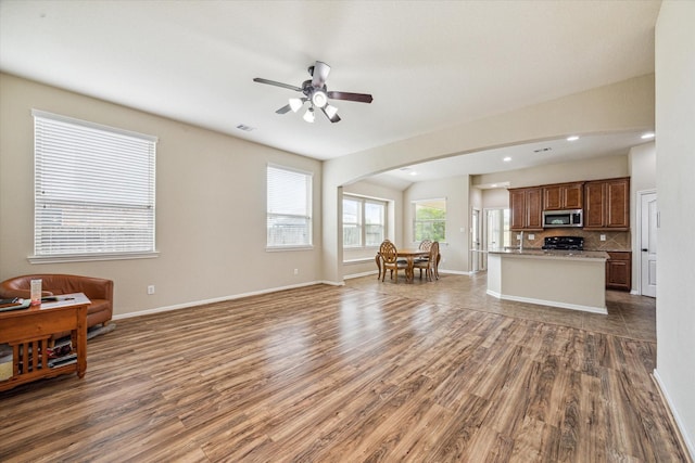 living room featuring ceiling fan, wood finished floors, visible vents, and baseboards