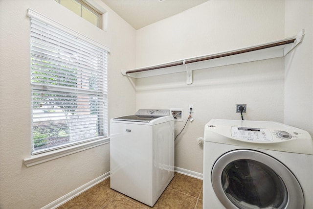 washroom featuring laundry area, light tile patterned flooring, washer and clothes dryer, and baseboards