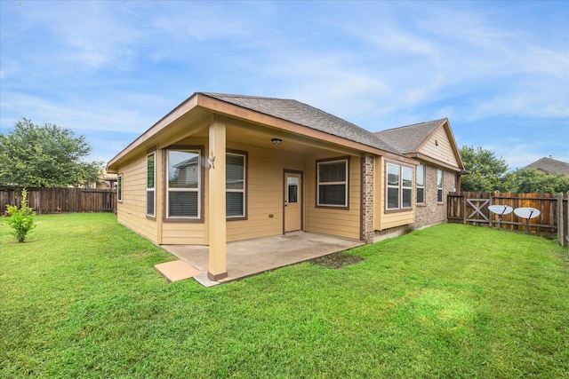 rear view of house with a patio area, a fenced backyard, and a lawn