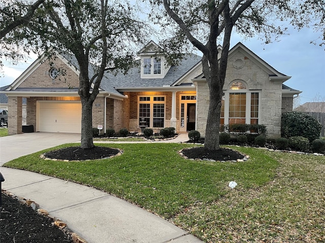 view of front of home featuring brick siding, concrete driveway, an attached garage, stone siding, and a front lawn