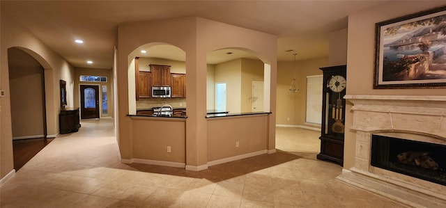 kitchen featuring a high end fireplace, stainless steel microwave, baseboards, and recessed lighting