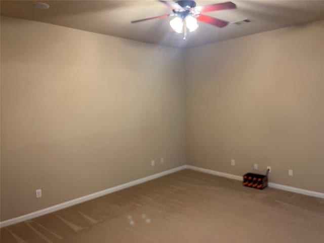 carpeted empty room featuring baseboards, visible vents, and ceiling fan