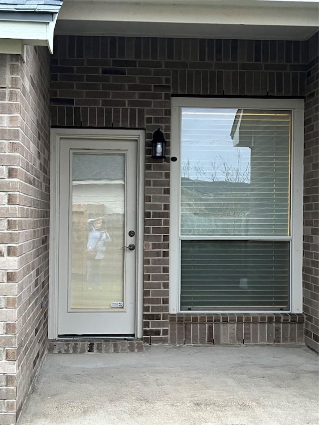 doorway to property with brick siding