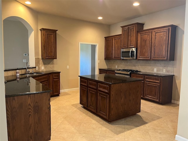 kitchen with appliances with stainless steel finishes, recessed lighting, a sink, and baseboards