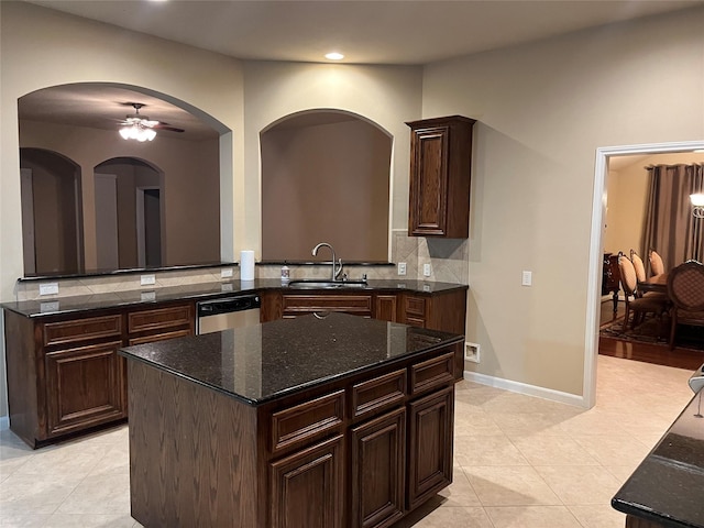 kitchen featuring dark stone countertops, a sink, decorative backsplash, and dishwasher