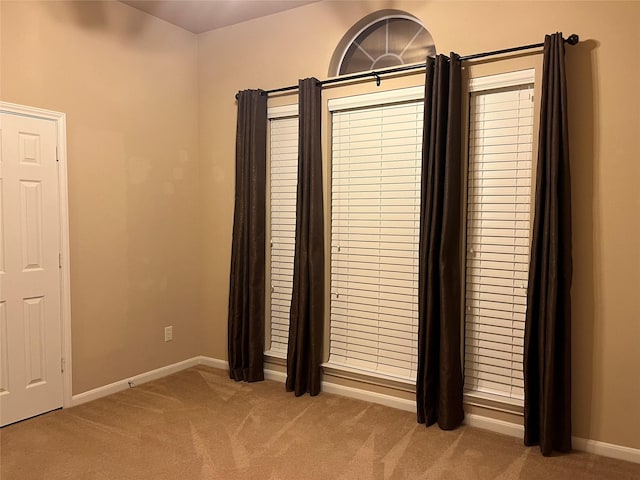 interior space with light carpet and baseboards