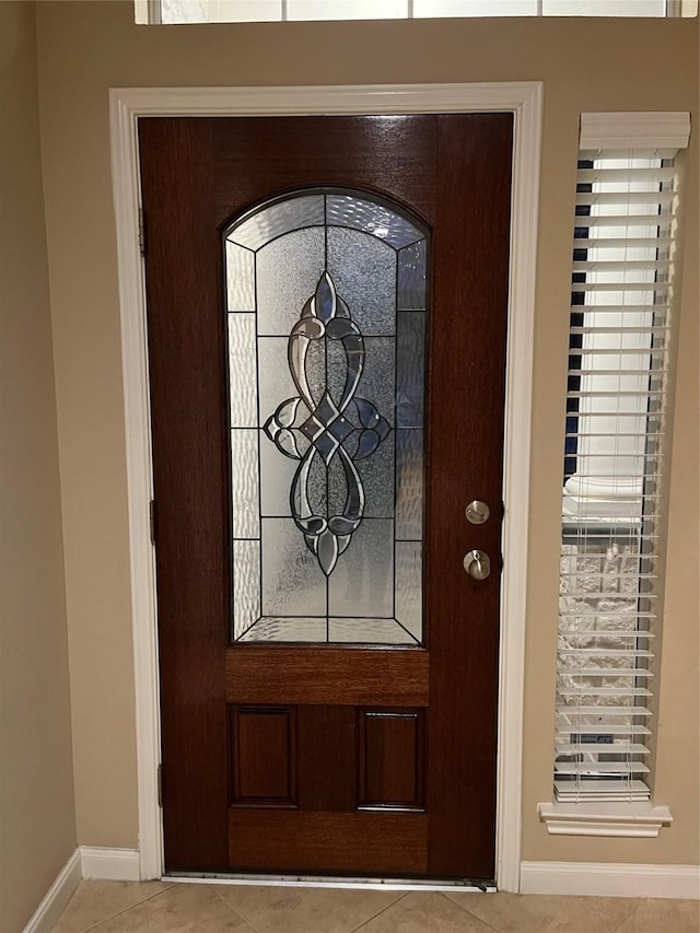 tiled foyer entrance featuring baseboards