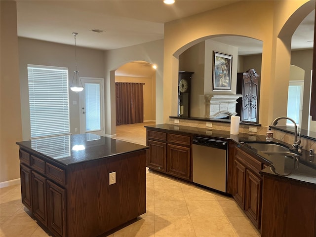 kitchen with light tile patterned floors, visible vents, a sink, dark stone counters, and dishwasher